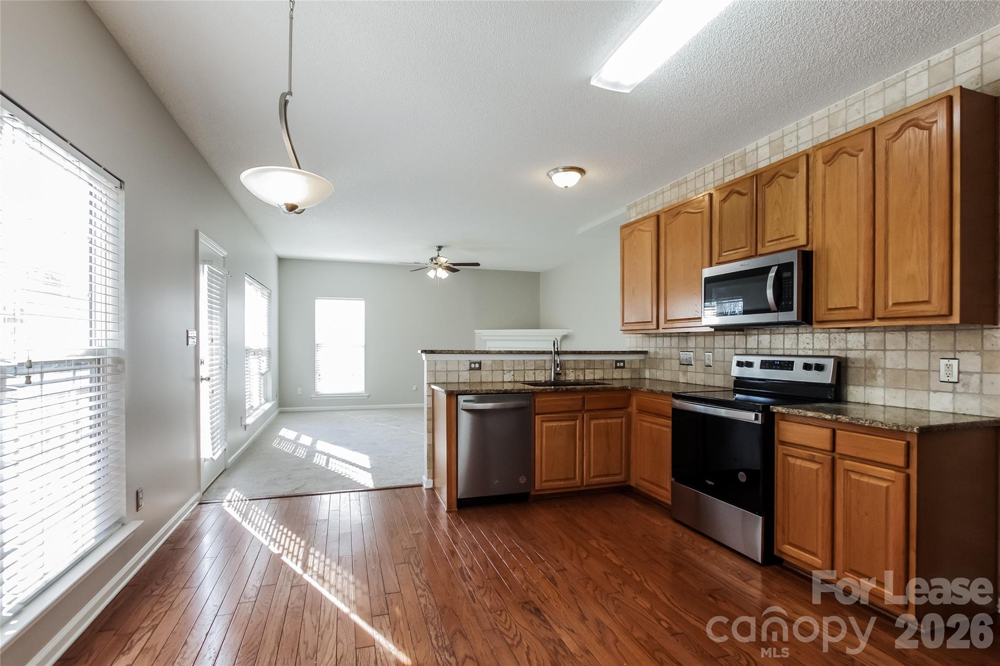 10802 Gold Pan Road Charlotte, NC 28215 - Photo 5 of 15 a large kitchen with granite countertop a stove and a sink
