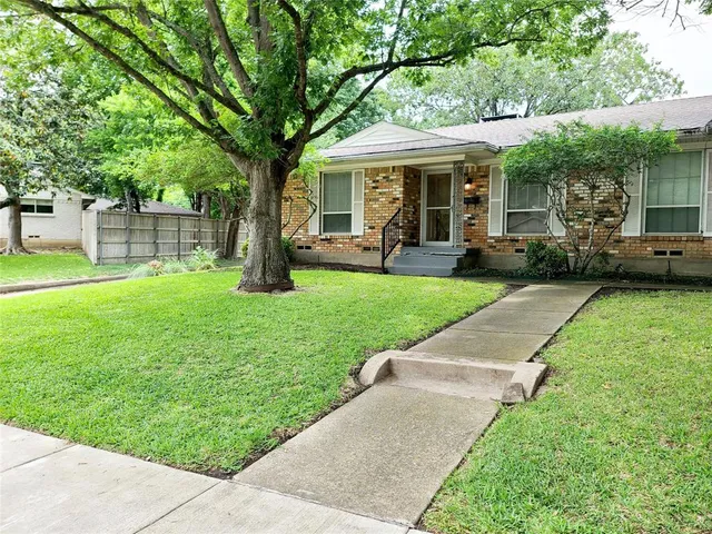a view of a house with a yard patio and a small yard