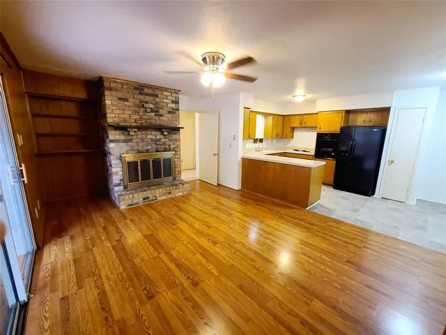 a view of empty room with a kitchen and wooden floor