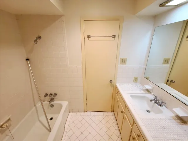 a bathroom with a sink a tub and a mirror