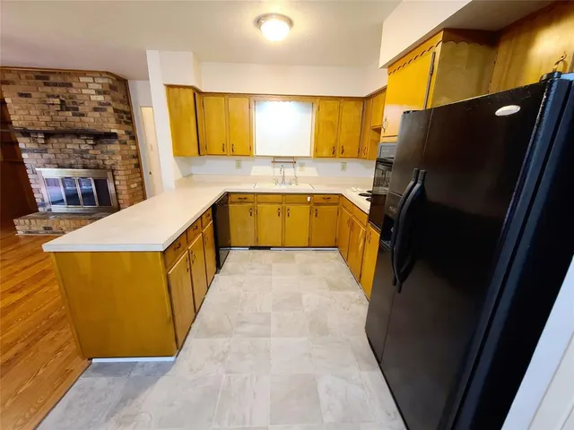 a bathroom with a granite countertop sink and a refrigerator