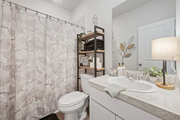 a bathroom with a granite countertop sink mirror vanity and toilet
