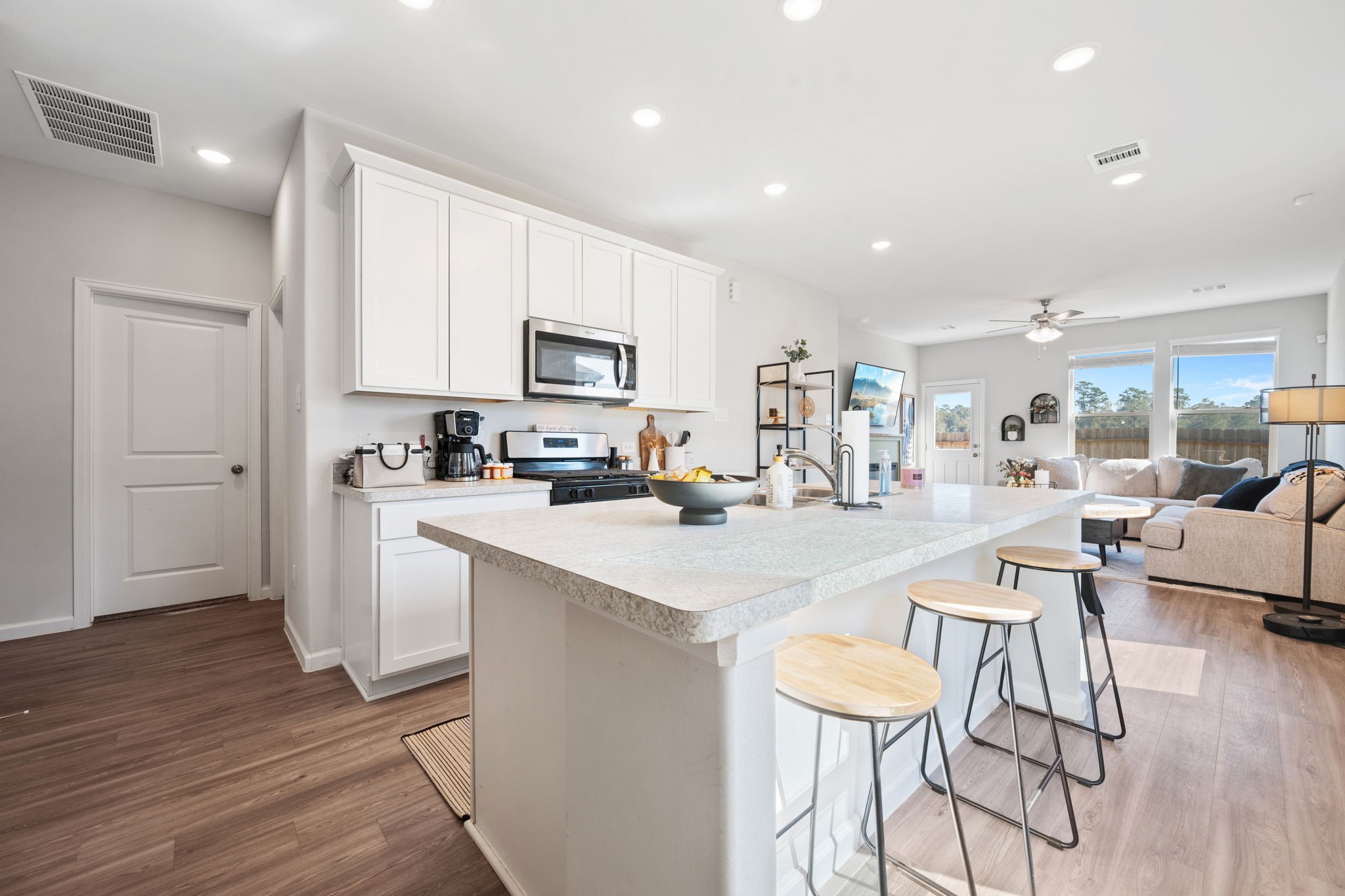 20819 Adventure Way Porter, TX 77365 - Photo 4 of 22 a kitchen with stainless steel appliances kitchen island granite countertop a stove a sink a refrigerator and white cabinets with wooden floor