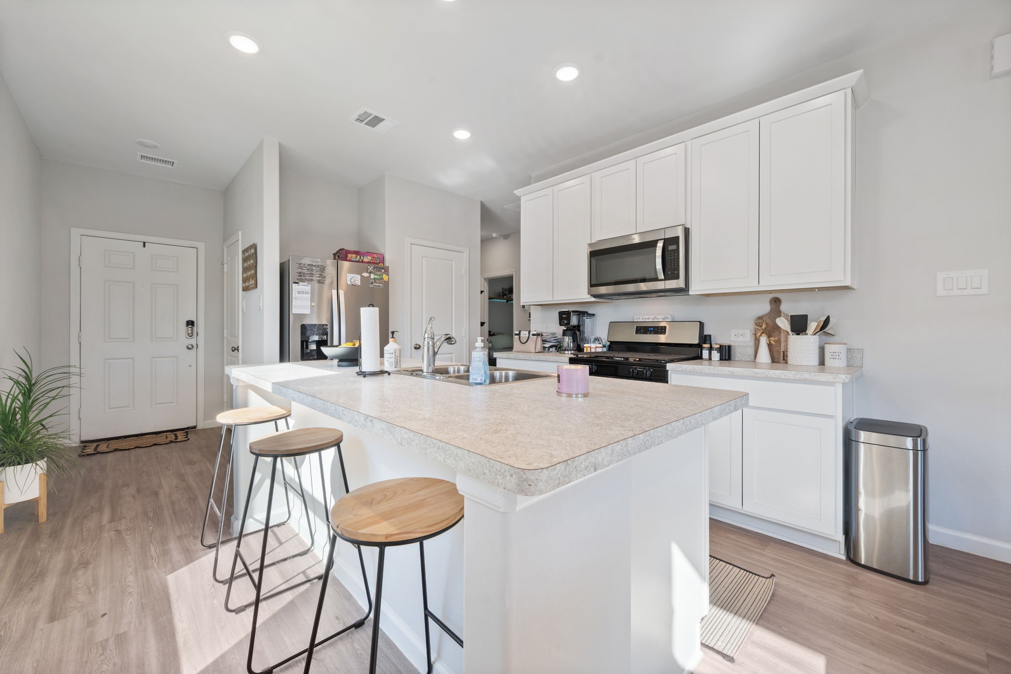 20819 Adventure Way Porter, TX 77365 - Photo 6 of 22 a kitchen with stainless steel appliances granite countertop a sink a stove a refrigerator a microwave oven with white cabinets and wooden floor