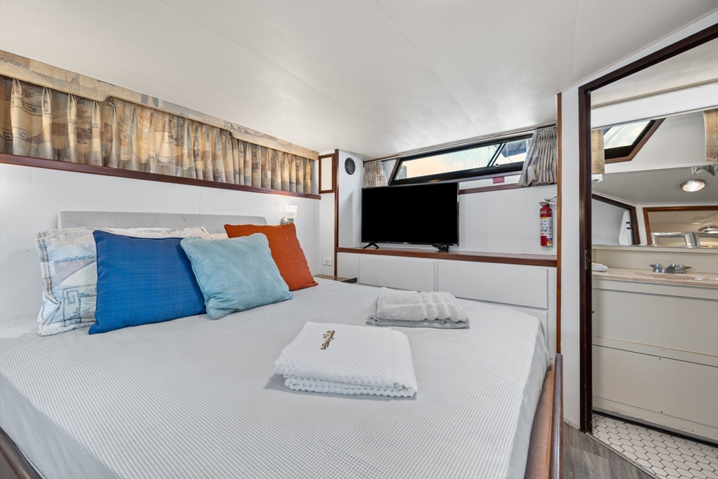 550 Pleasant Street, Unit 11D Winthrop, MA 02152 - Photo 13 of 30 a bedroom with a bed and a flat screen tv