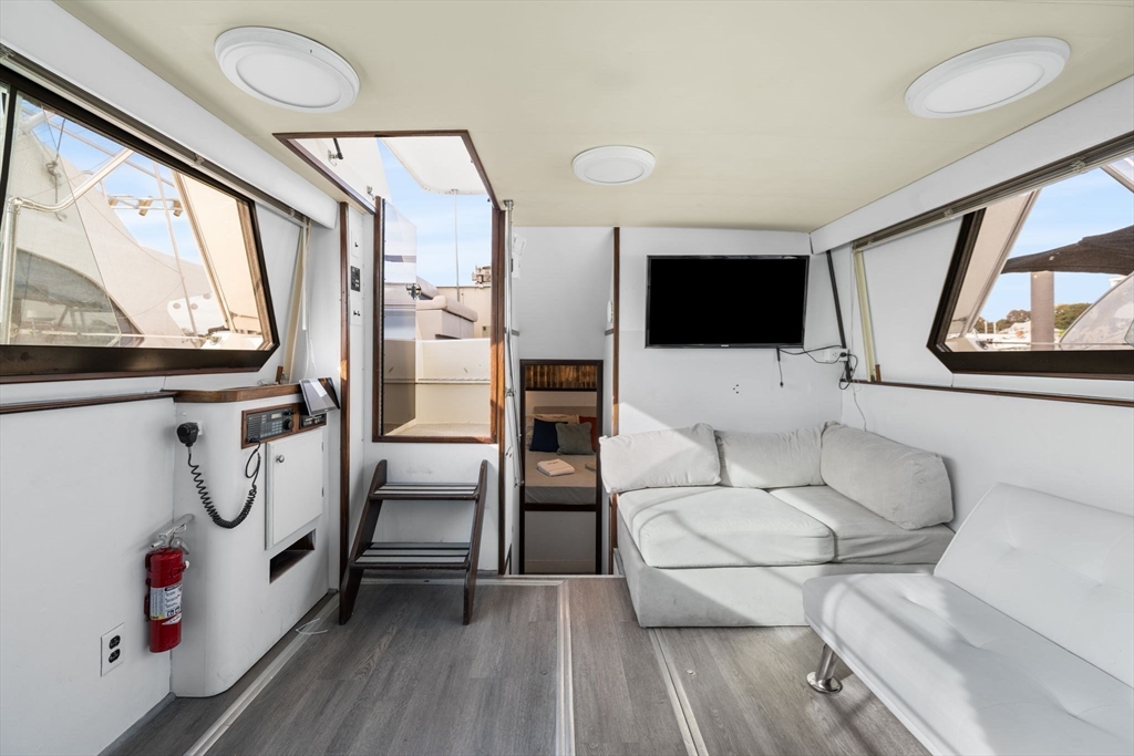 550 Pleasant Street, Unit 11D Winthrop, MA 02152 - Photo 8 of 30 a living room with furniture a flat screen tv and a large window