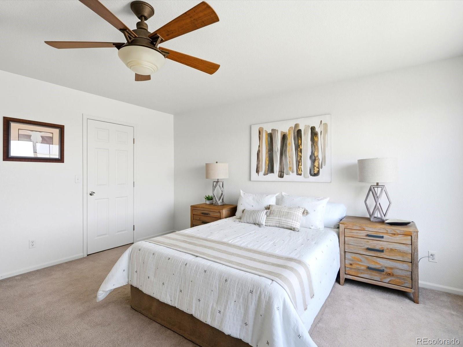 5444 Perth Court Denver, CO 80249 - Photo 26 of 46 a bedroom with a bed and lamp