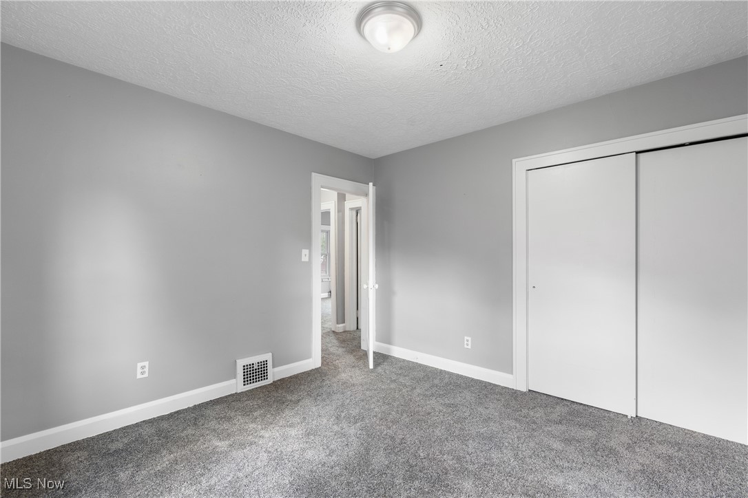 302 Poplar Avenue Northwest Canton, OH 44708 - Photo 23 of 34 Unfurnished bedroom with carpet flooring, a textured ceiling, and a closet