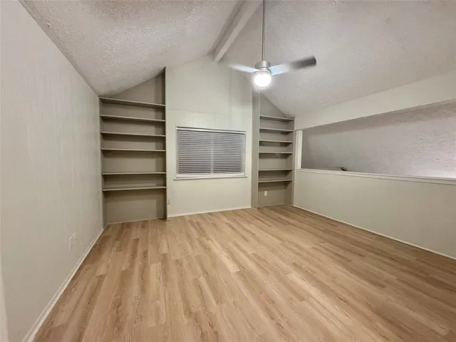 a view of an empty room with a fireplace and a window