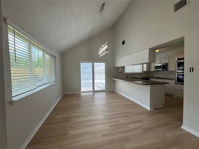 a kitchen with stainless steel appliances kitchen island granite countertop a stove and a large window