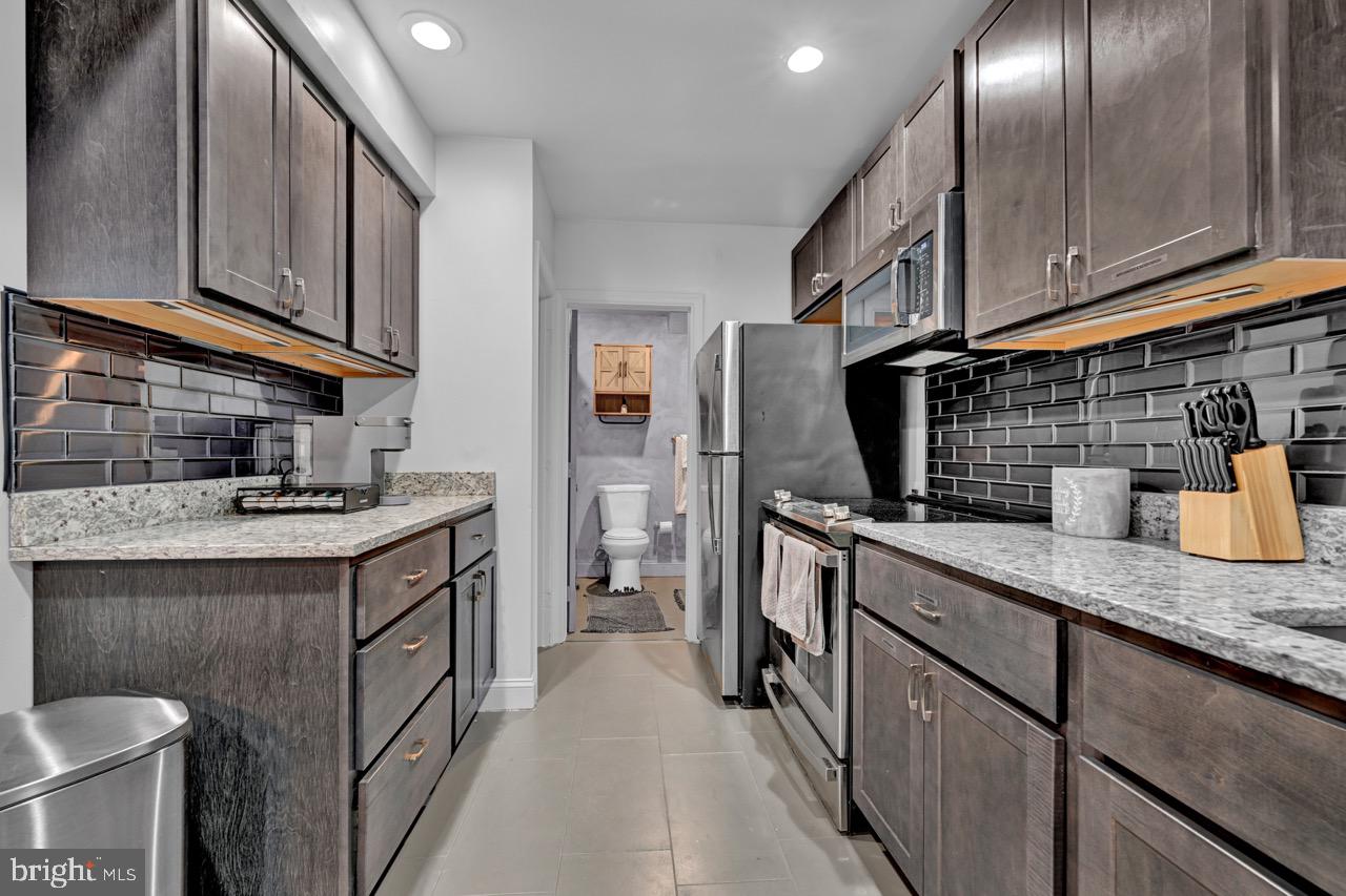 1709 Bank Street Baltimore, MD 21231 - Photo 37 of 49 a kitchen with stainless steel appliances granite countertop a sink stove and refrigerator