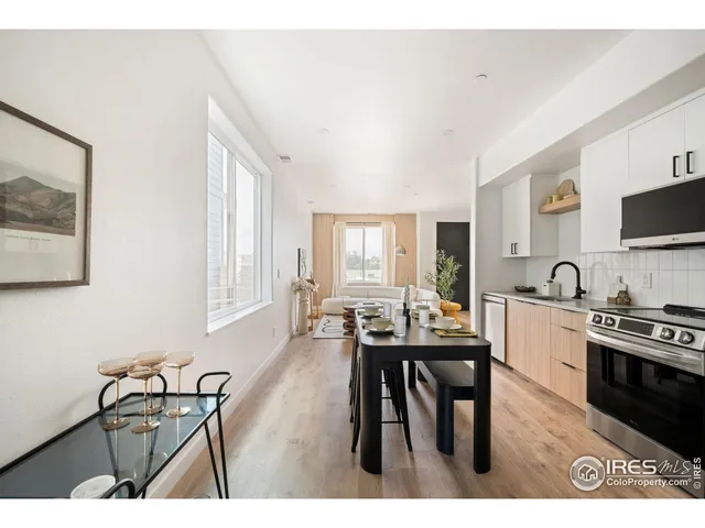 a kitchen with stainless steel appliances a stove a sink a microwave and white cabinets