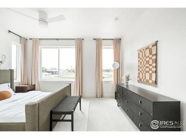 a bedroom with a bed and a large window