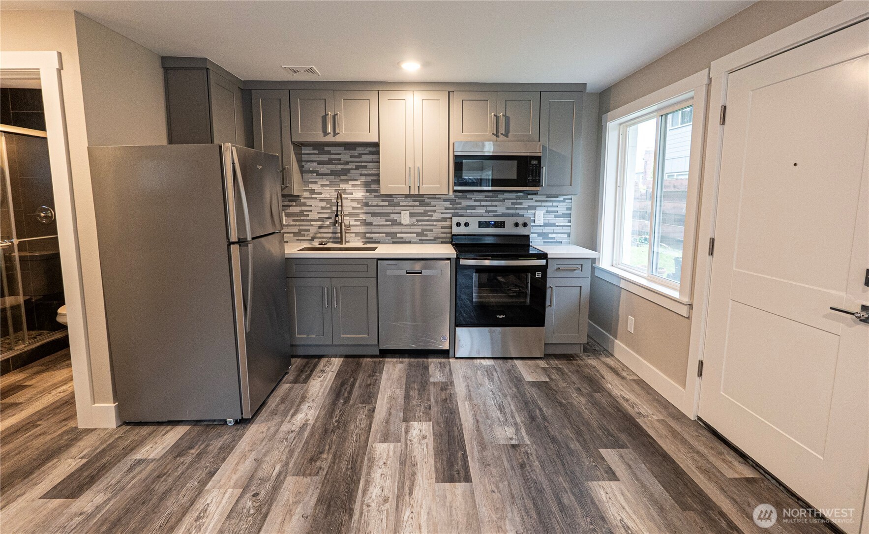 3035 64th Avenue Southwest Seattle, WA 98116 - Photo 9 of 14 a kitchen with stainless steel appliances a refrigerator stove and microwave