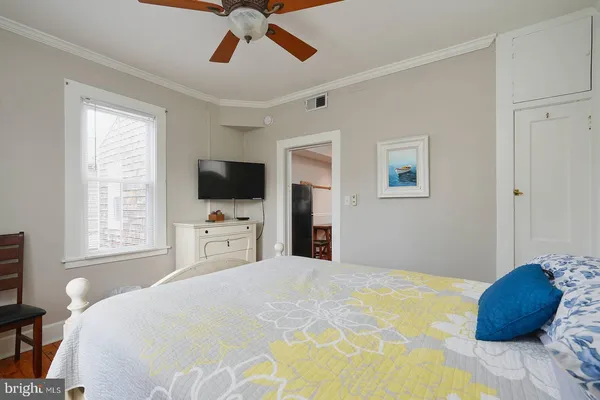 a bedroom with a bed and a flat tv screen on dresser