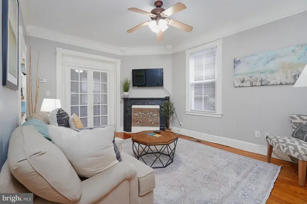 a living room with furniture a flat screen tv and a dining table