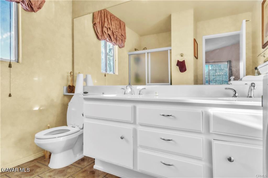 2309 Gregory Avenue Palmdale, CA 93550 - Photo 16 of 29 a bathroom with a sink toilet and mirror