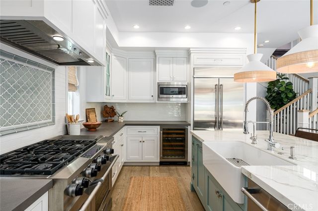 a kitchen with stainless steel appliances a sink a stove and a wooden cabinets