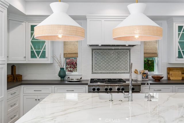 a kitchen with stainless steel appliances granite countertop a stove and a white cabinet