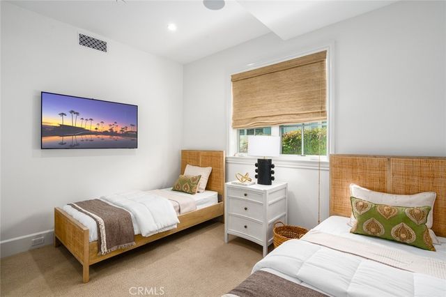 a bathroom with a toilet a sink a mirror and a window