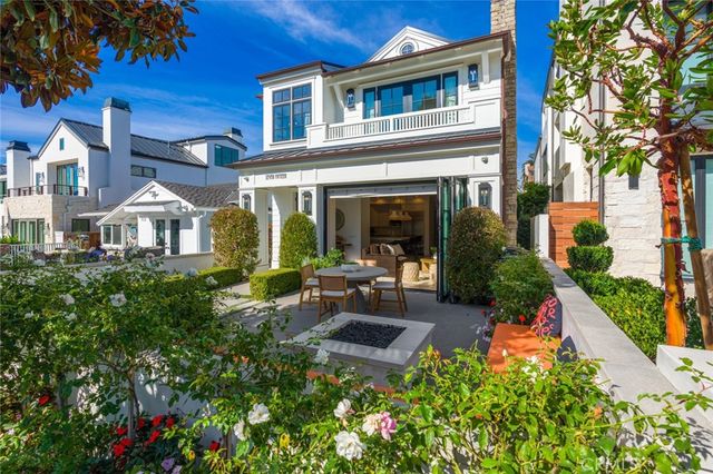 a front view of a house with lots of flowers planted