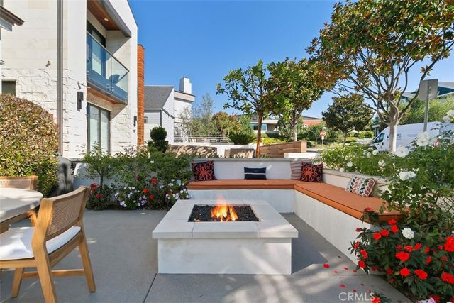 a very nice looking open dining room with kitchen island furniture a large window and a chandelier