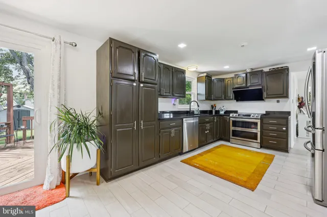 a kitchen with stainless steel appliances kitchen island granite countertop a refrigerator and a stove top oven