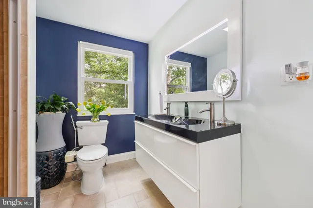 a living room with furniture a window and a potted plant