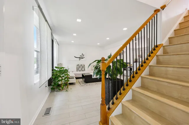 a hallway with wooden floor stairs and stairs