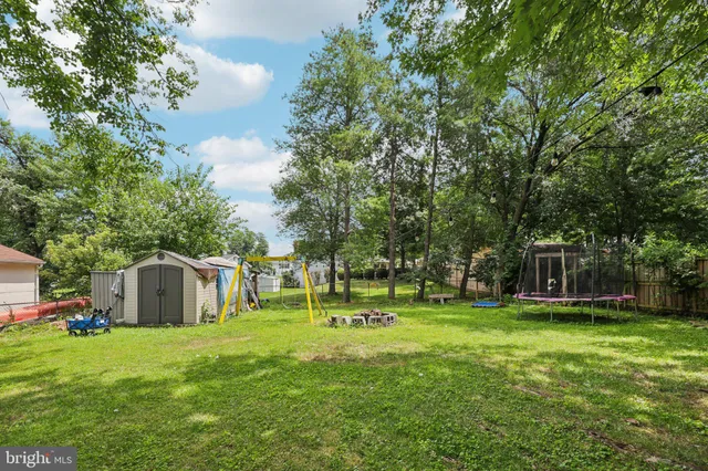 a view of a house with a big yard and large trees