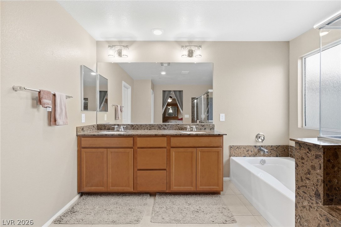 150 Fulgora Street Henderson, NV 89074 - Photo 49 of 92 Bathroom with double vanity, a garden tub, and light tile patterned flooring