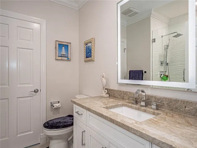 a bathroom with a granite countertop sink a toilet and a mirror