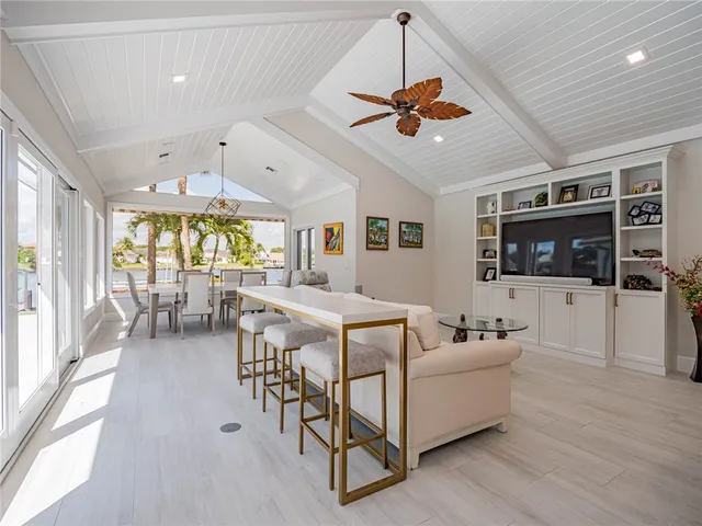 a living room with furniture a chandelier and a flat screen tv