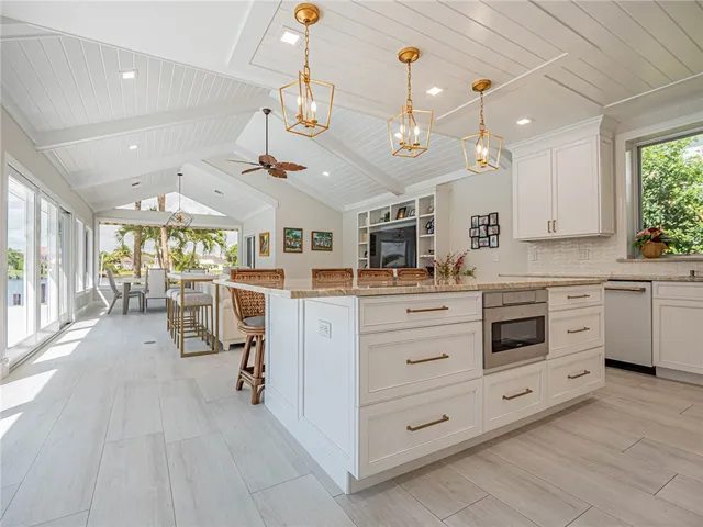 a large white kitchen with a large window cabinets and stainless steel appliances