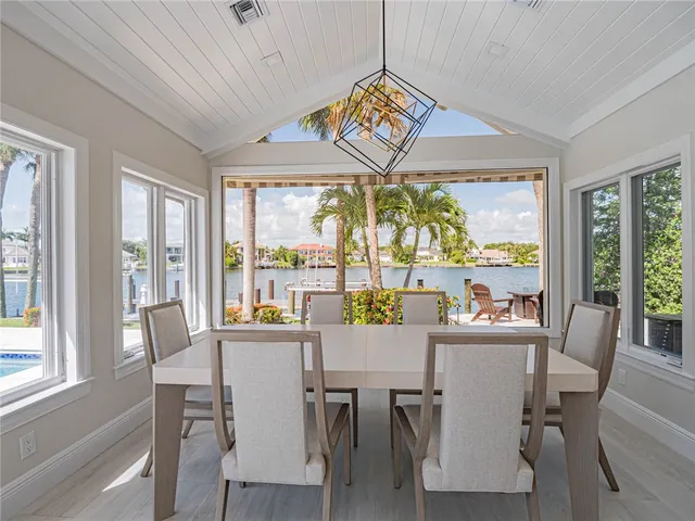 a view of a dining room with furniture large windows wooden floor and chandelier