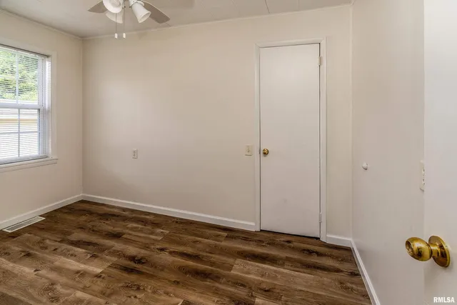 a view of a room with wooden floor and fan