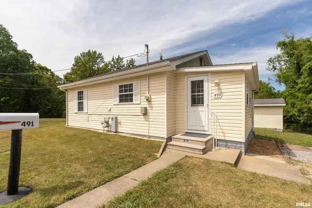 a view of a house with backyard and sitting area