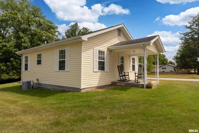 a view of a house with a yard and sitting area