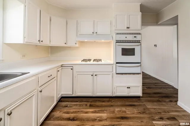 a kitchen with white cabinets and white appliances
