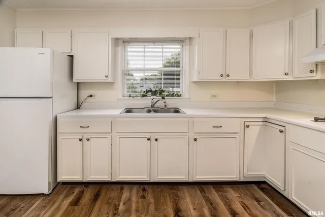 a kitchen with white cabinets white appliances and sink