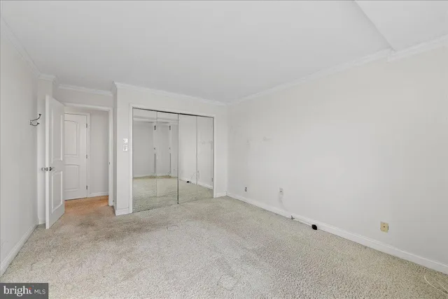 an empty room with a window and closet