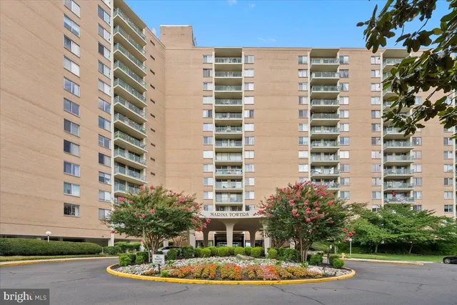 a kitchen with stainless steel appliances granite countertop a refrigerator a stove and a sink with wooden floors