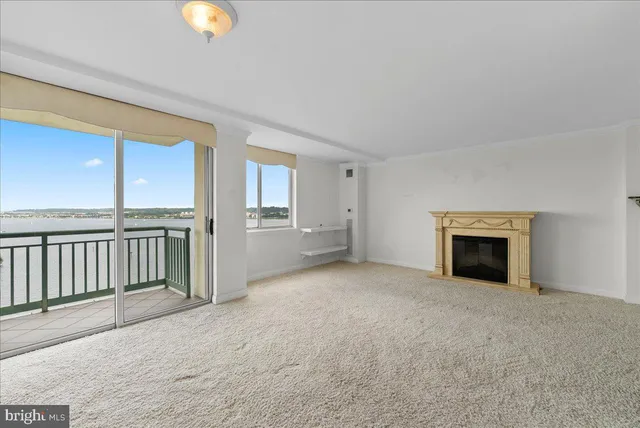 a view of an empty room with a fireplace and a window