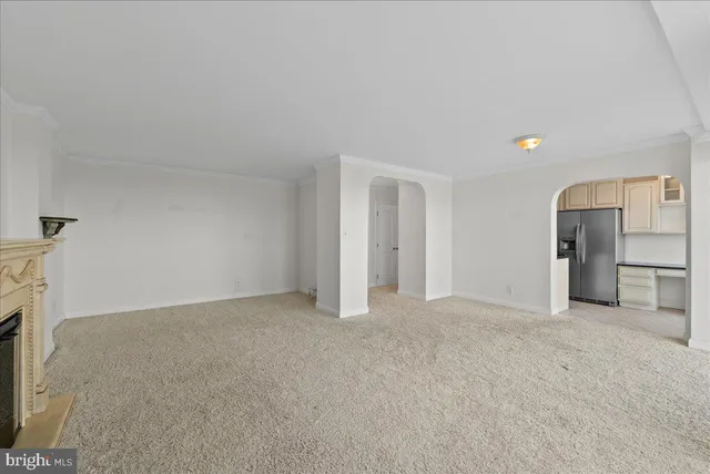 a view of empty room with a kitchen