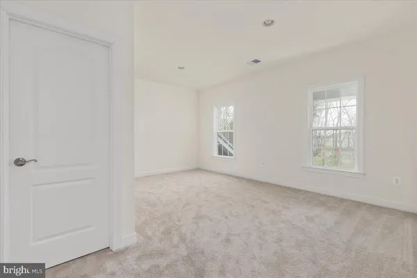 a front view of a house with a garden and trees