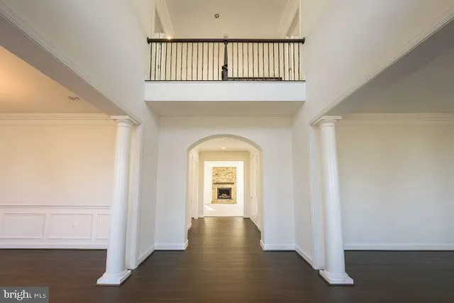 a view of a hallway with wooden floor and a living room