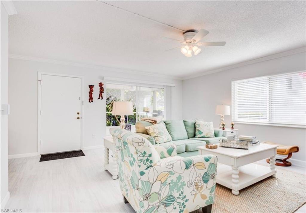 372 4th Avenue South, Unit 372 Naples, FL 34102 - Photo 4 of 14 Living room featuring ornamental molding, a textured ceiling, ceiling fan, and light wood-type flooring