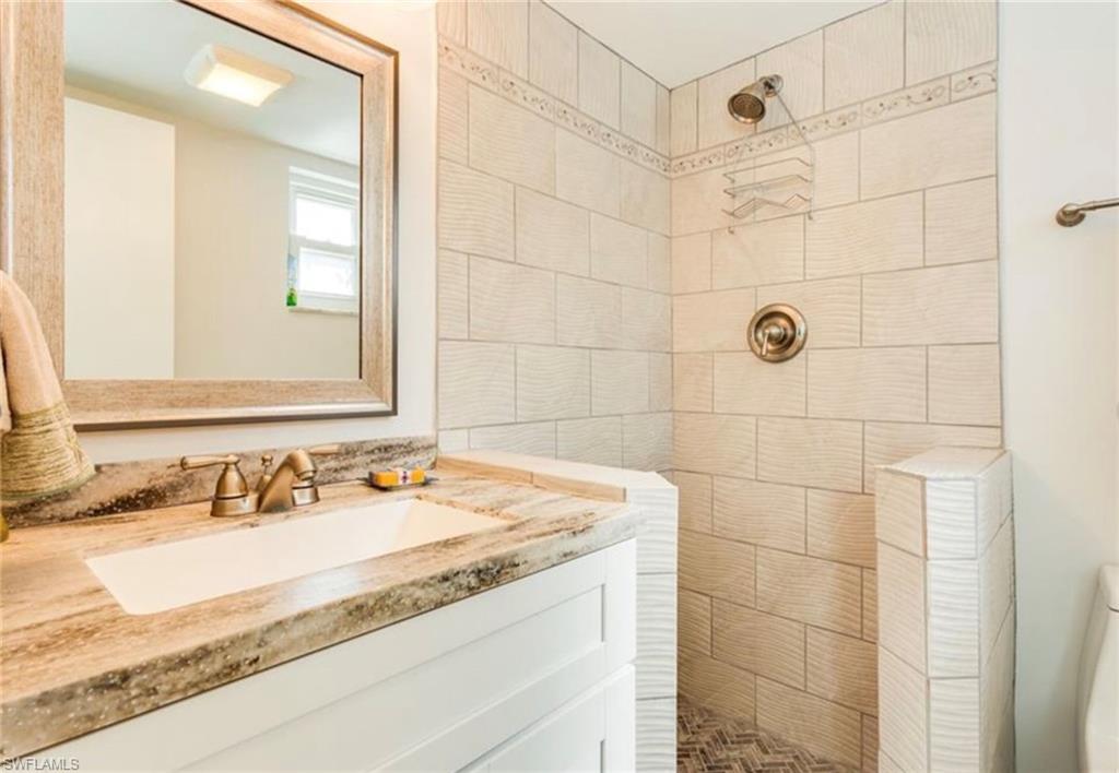 372 4th Avenue South, Unit 372 Naples, FL 34102 - Photo 9 of 14 Full bathroom with walk in shower and vanity
