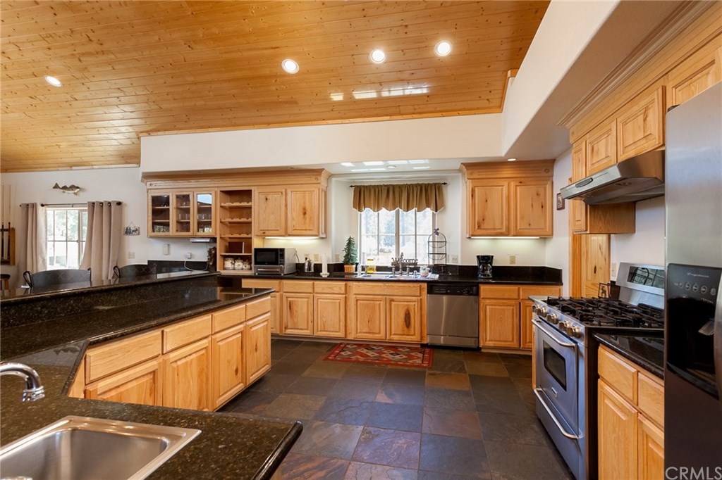 209 Rodeo Road Big Bear City, CA 92314 - Photo 11 of 39 a kitchen with stainless steel appliances granite countertop a sink and stove