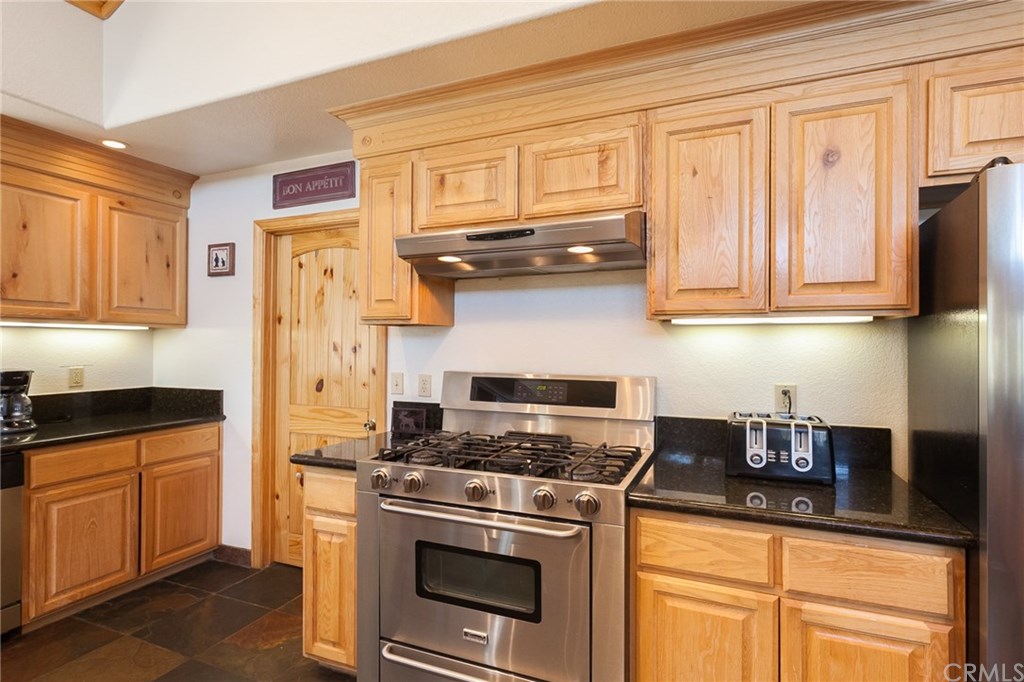 209 Rodeo Road Big Bear City, CA 92314 - Photo 13 of 39 a kitchen with stainless steel appliances granite countertop a stove a refrigerator and a cabinets